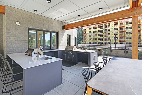 a patio with tables and chairs and a bar with two sinks