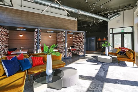 A modern living room with a wooden bench and a vase with a green plant on the table.