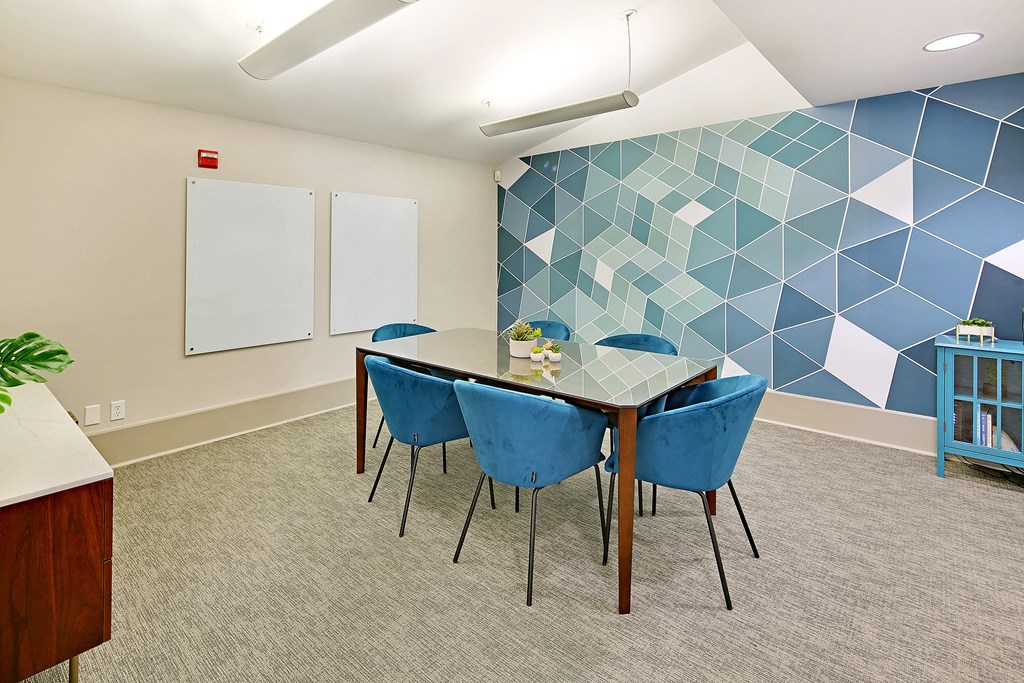 a conference room with a table and chairs and a blue wall with a geometric design
