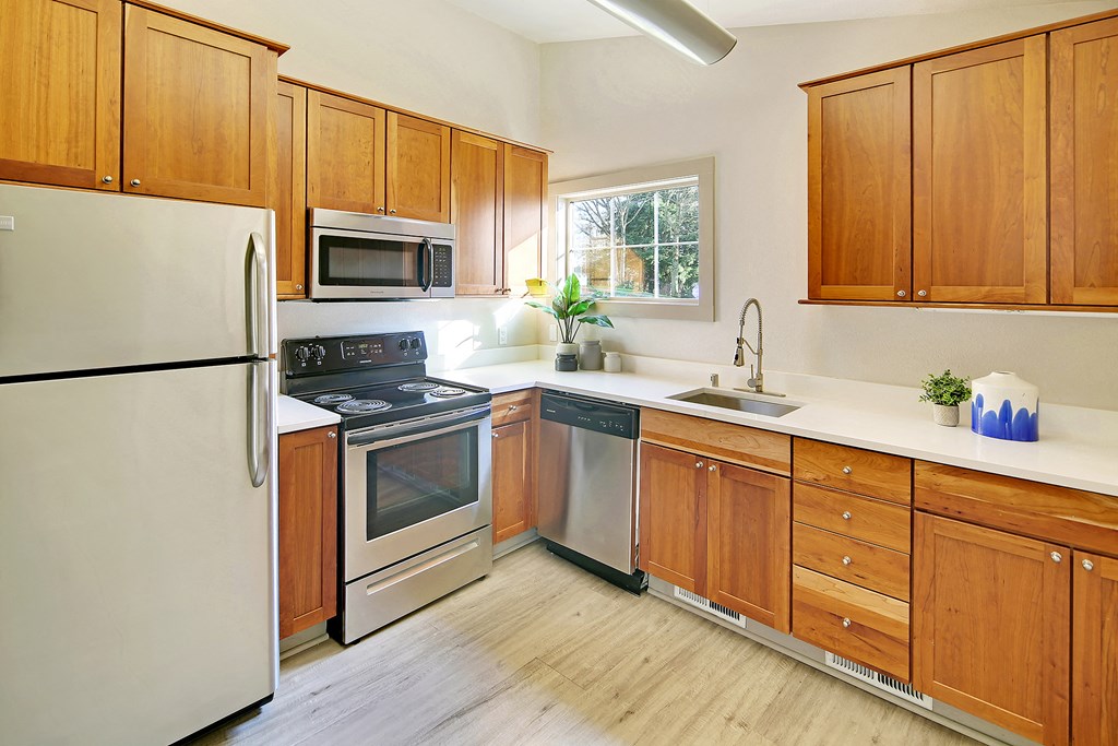 a kitchen with wooden cabinets and stainless steel appliances