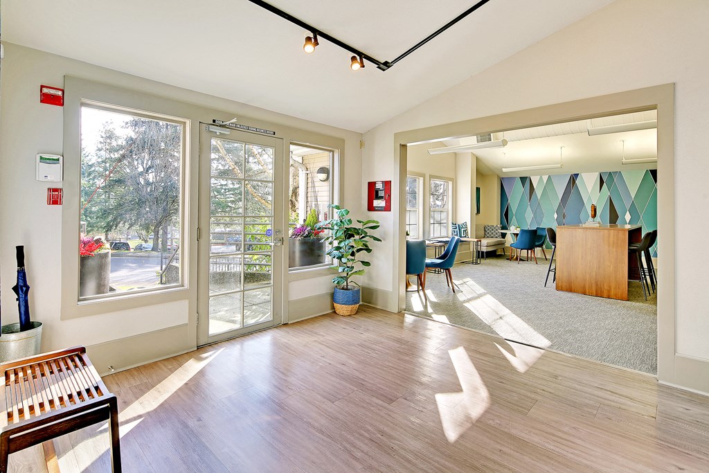 the lobby of a building with glass doors and a table and chairs