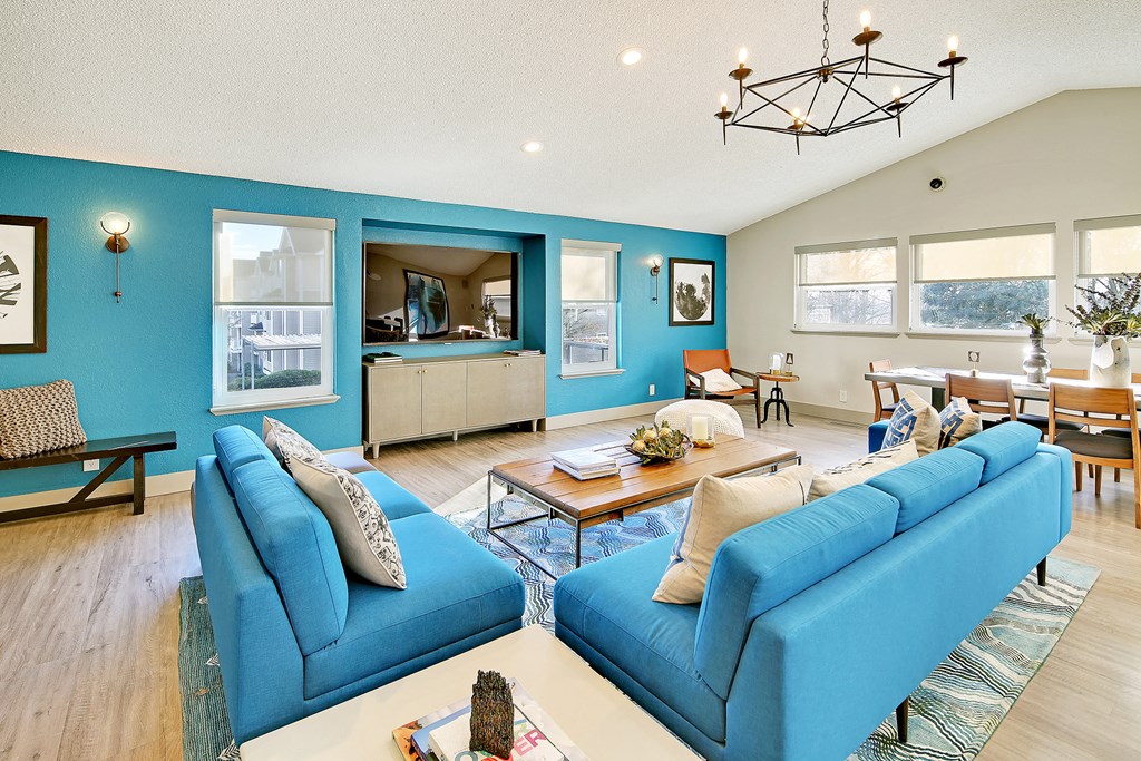 a living room with blue couches and a table