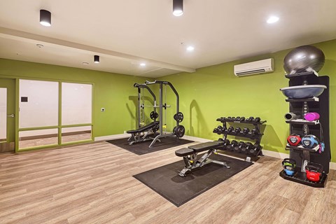 a home gym with green walls and a wooden floor