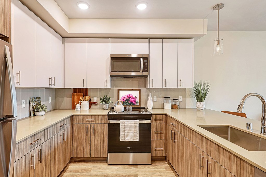 a kitchen with white cabinets and a large island with a sink and stove