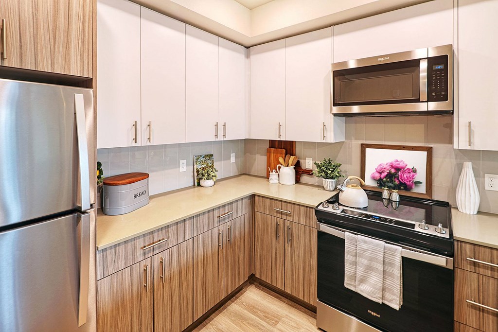 a kitchen with white cabinets and black appliances