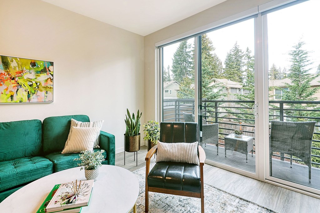 a living room with a green couch and a sliding glass door