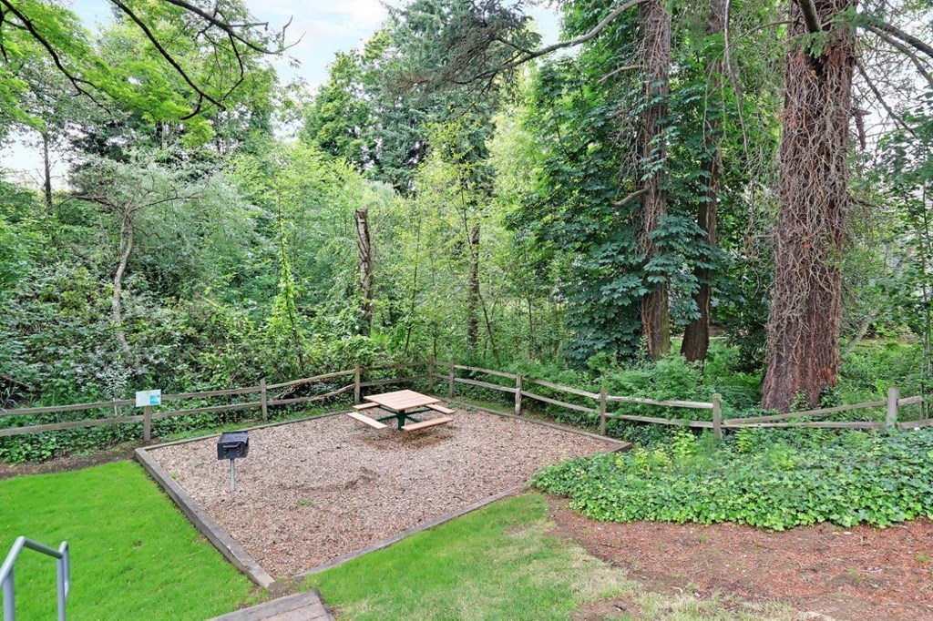 a backyard with a picnic table and a fire pit