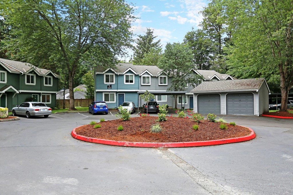 a circle of landscaping in front of a house