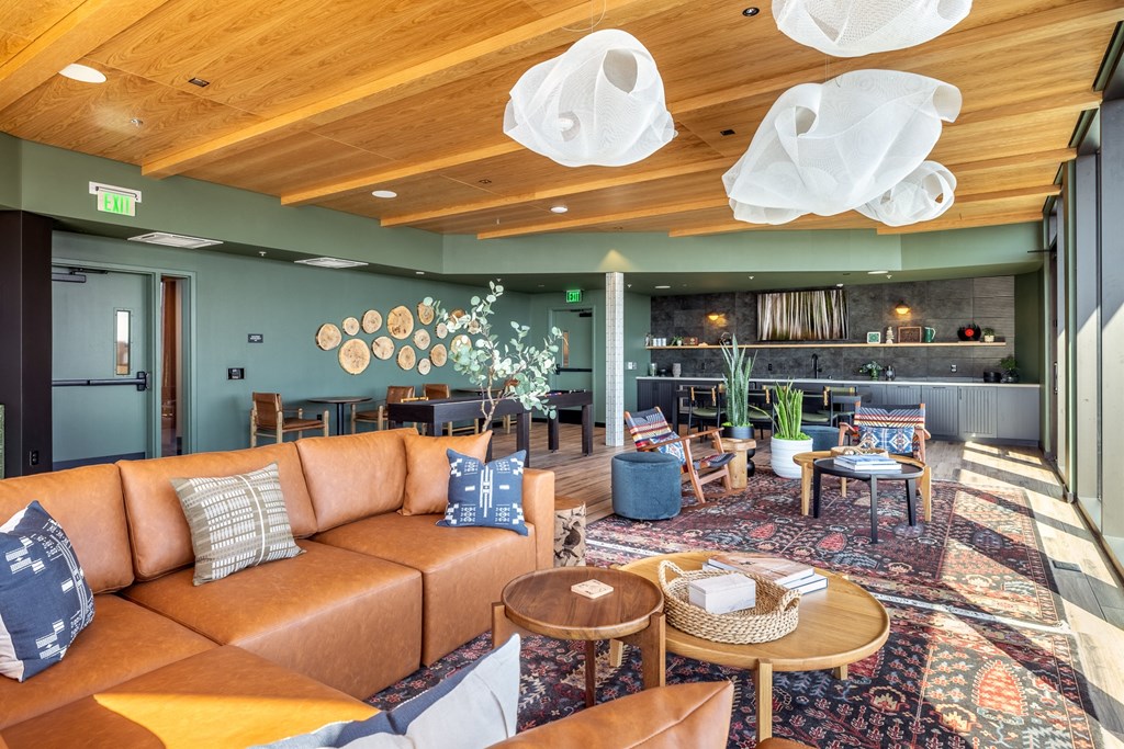 A room with a brown leather couch and a wooden table.