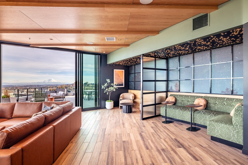 A modern living room with a view of the cityscape outside the large windows.