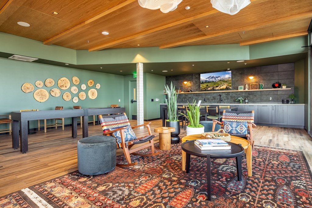 A living room with a wooden ceiling and a rug on the floor.