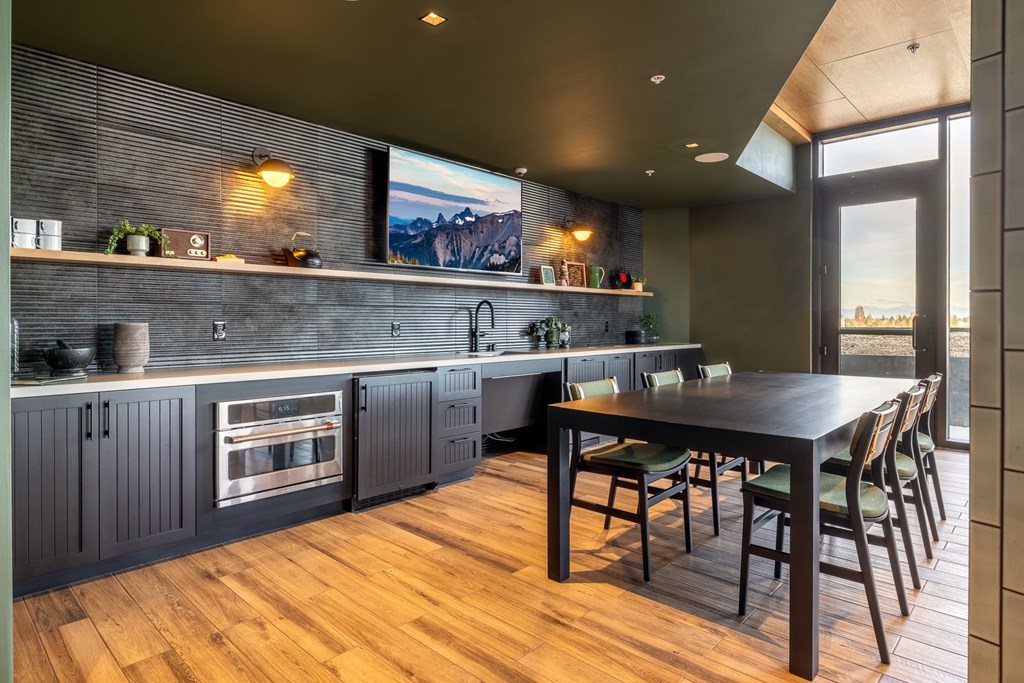 A modern kitchen with a wooden table and chairs.