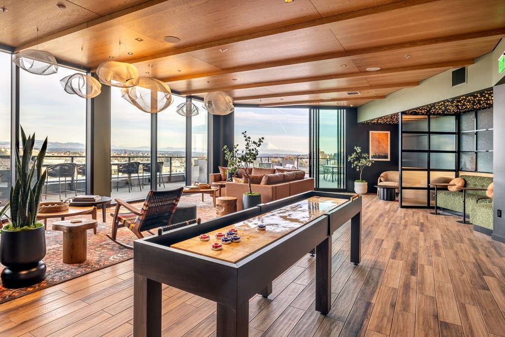 A room with a pool table and a view of the city.