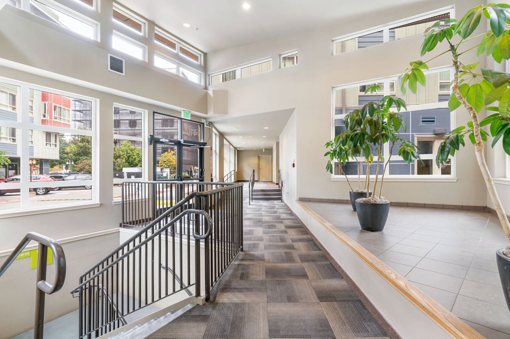the lobby of a building with stairs and large windows