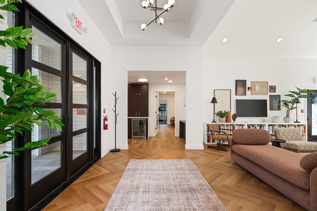 A living room with a brown couch and a rug.
