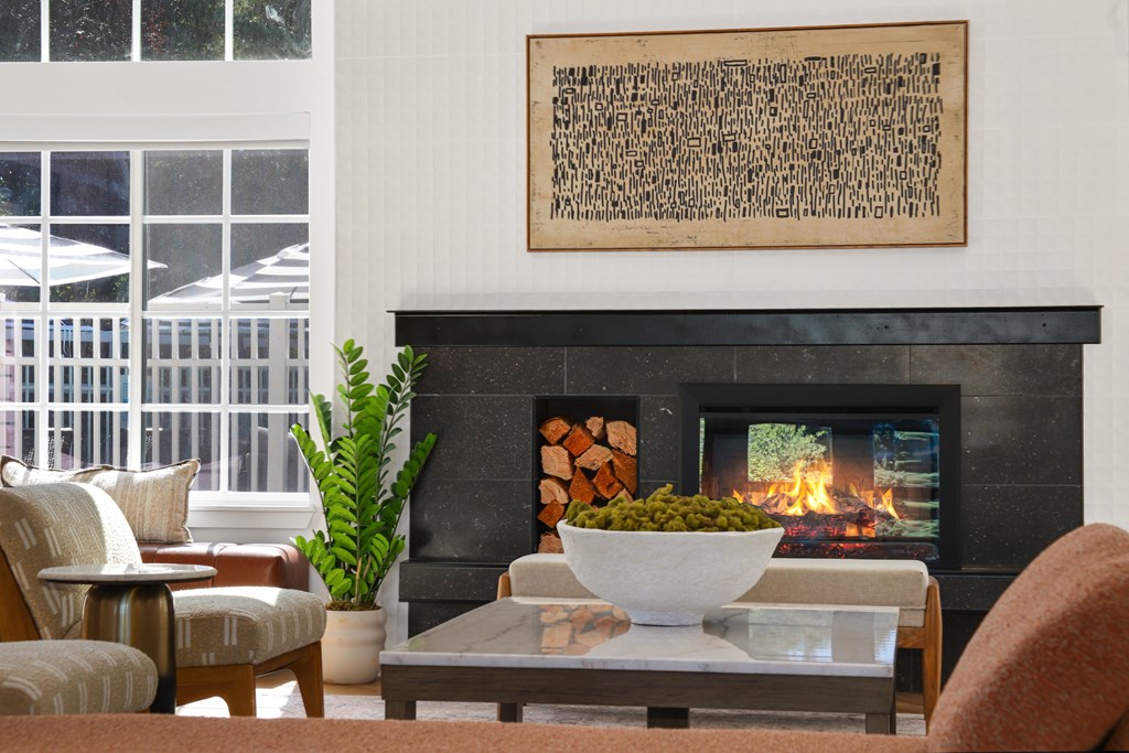 A living room with a fireplace and a painting above it.