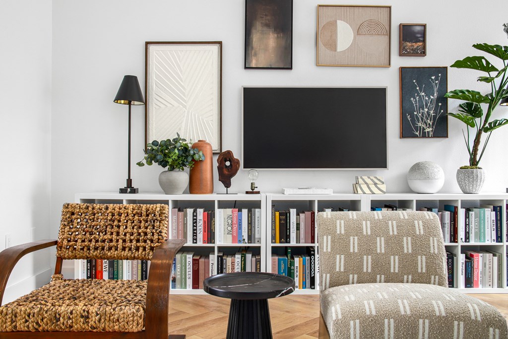 A living room with a chair, a table, and a bookshelf.