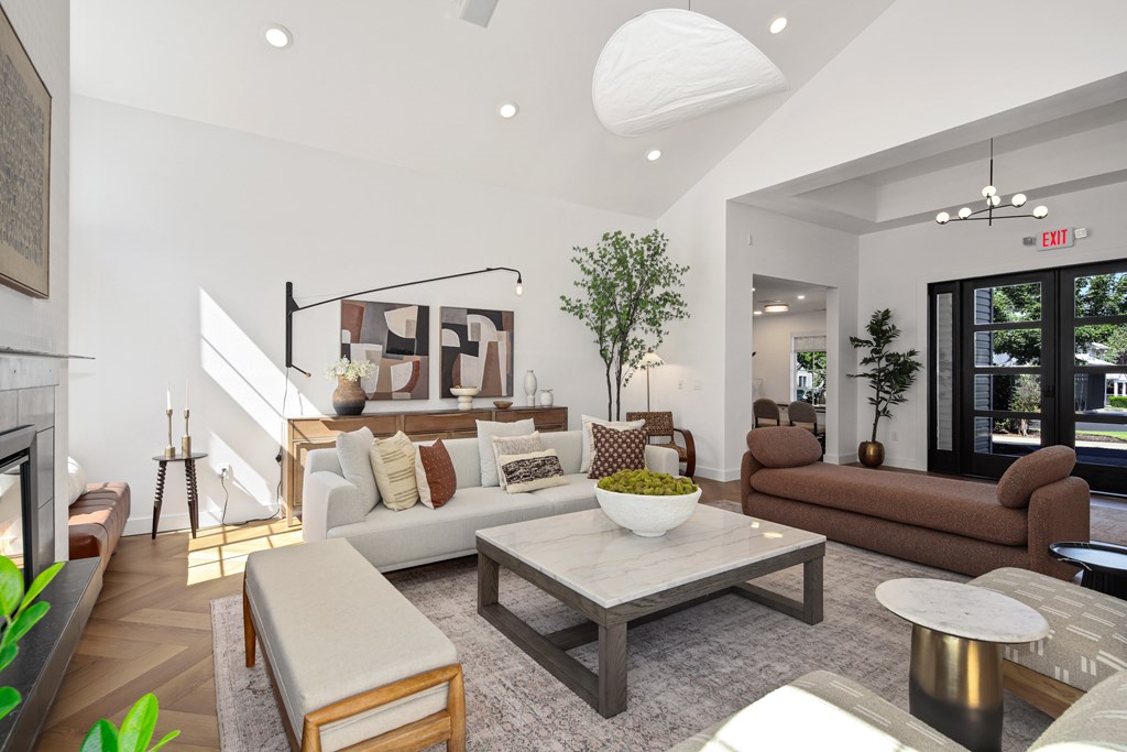 A living room with a white couch, a coffee table, and a fireplace.