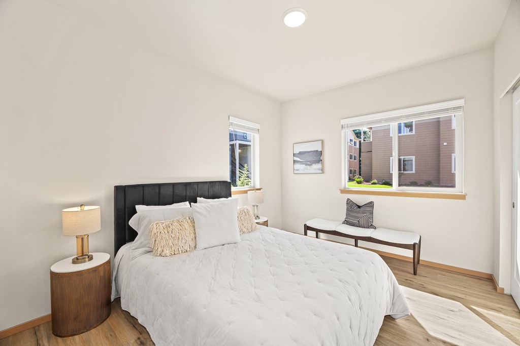 A bedroom with a large bed and a window overlooking a building.