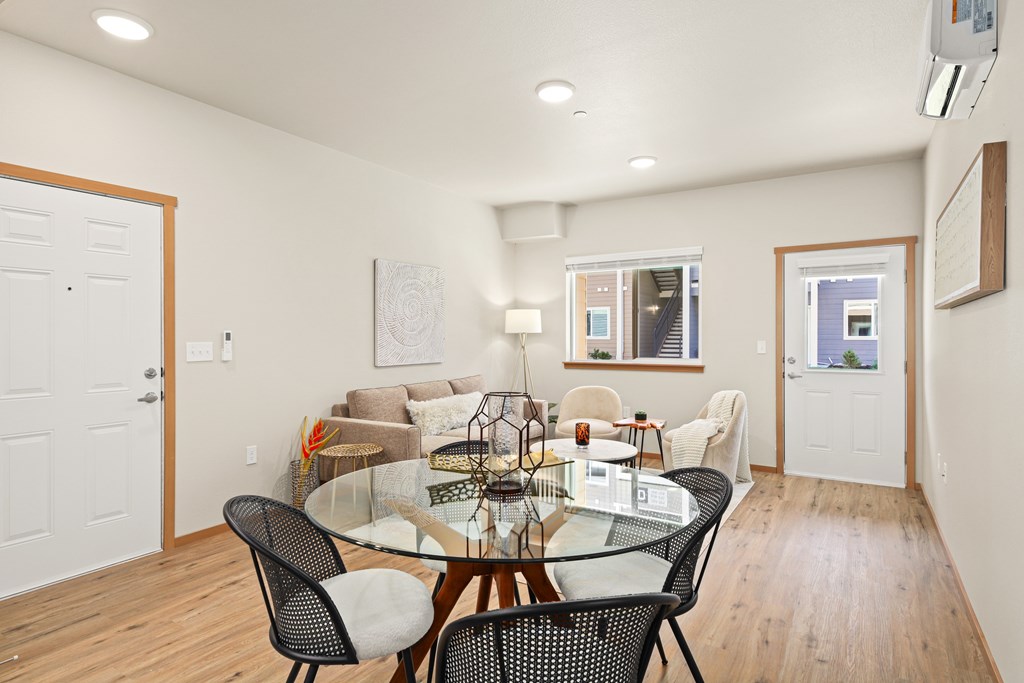 A dining room with a glass table and chairs.