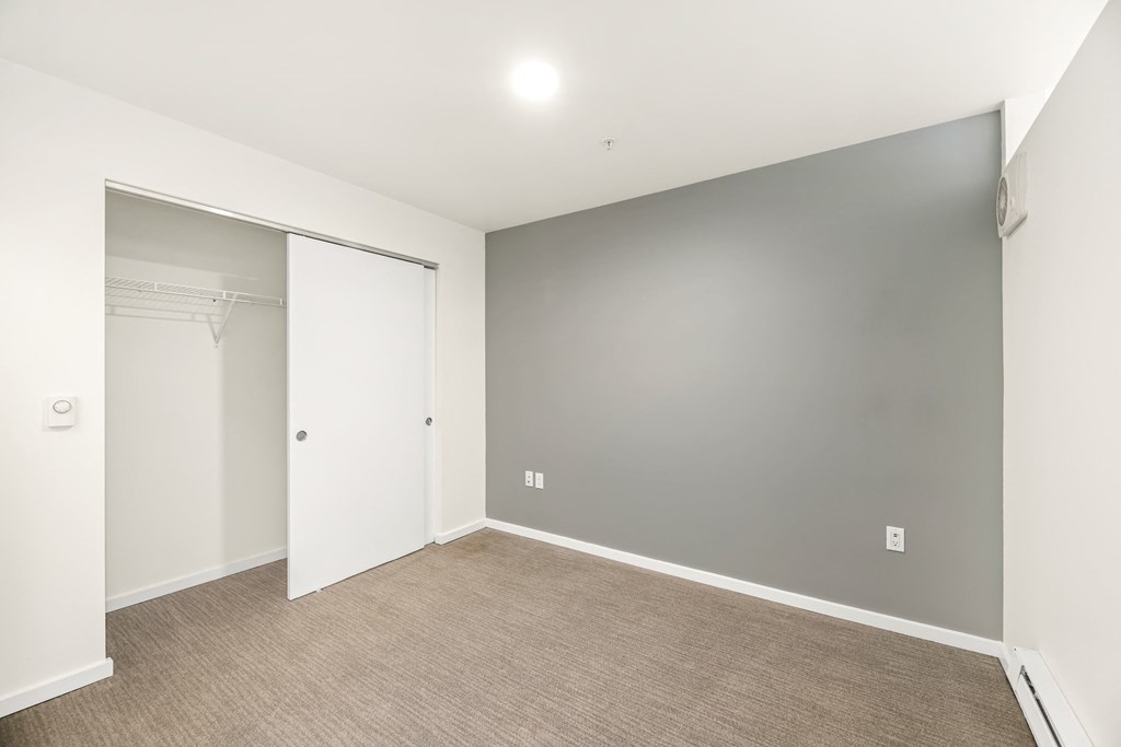 A room with a white door and a grey wall.