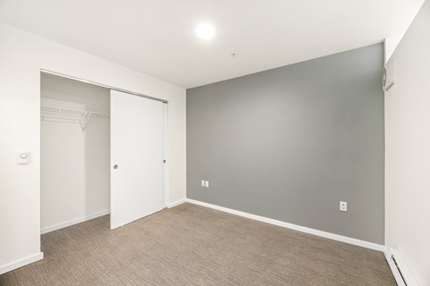 A room with a white door and a grey wall.
