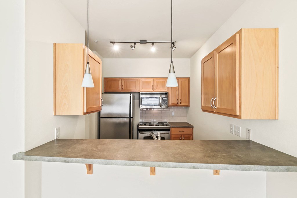 a kitchen with wooden cabinets and a marble counter top
