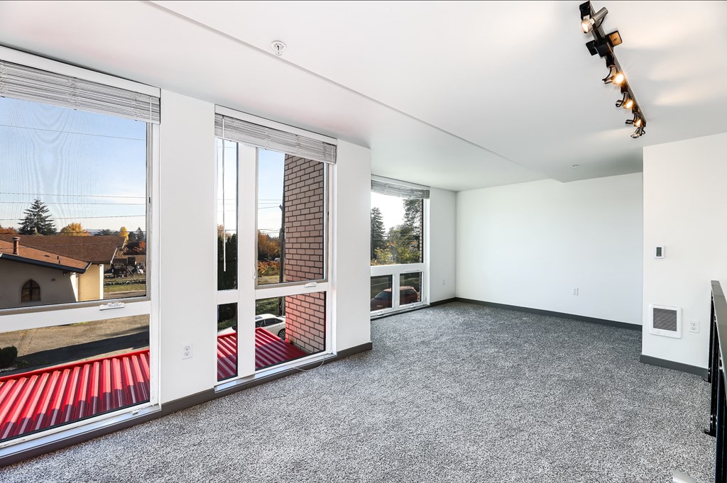 a living room with large windows and a concrete floor