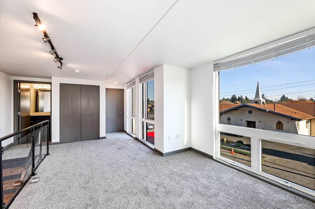a living room with a large window and a view of a building in the distance