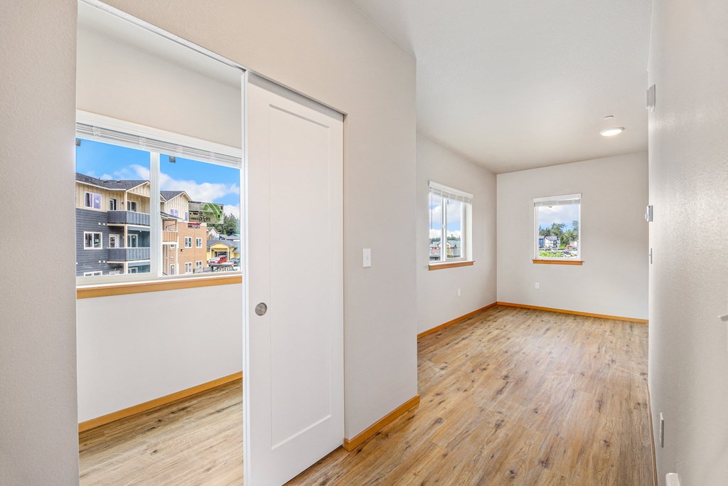 a spacious living room with wood floors and white walls