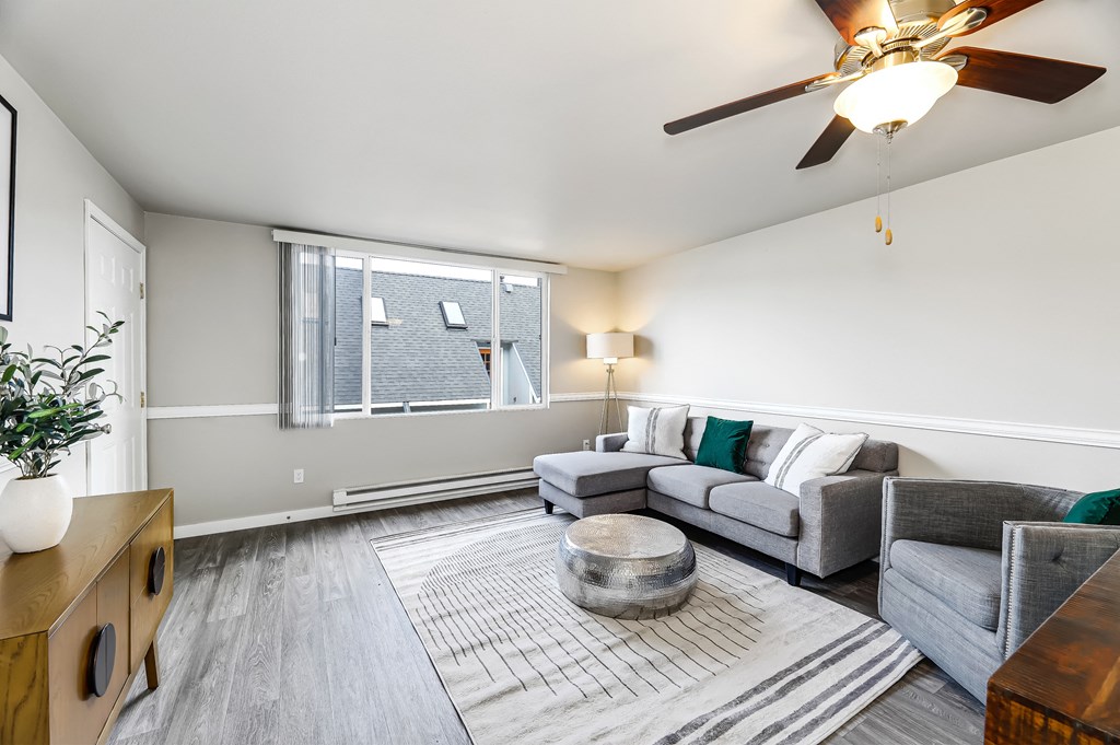 a living room with a ceiling fan and a large window