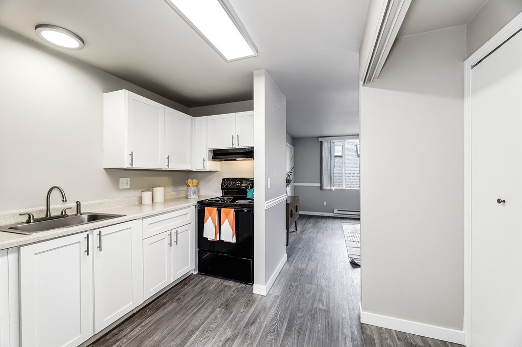 a kitchen with white cabinets and black appliances