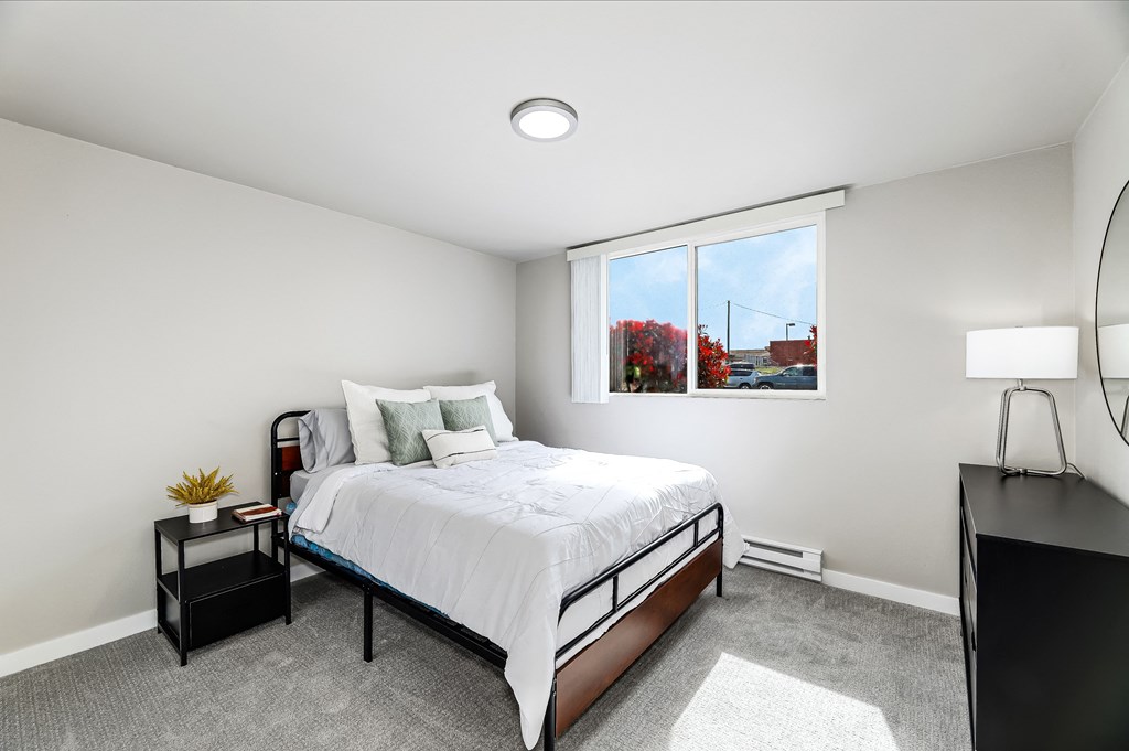 a bedroom with a bed and a large window