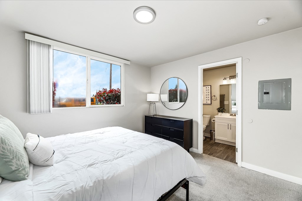 a bedroom with a bed and a dresser with a mirror