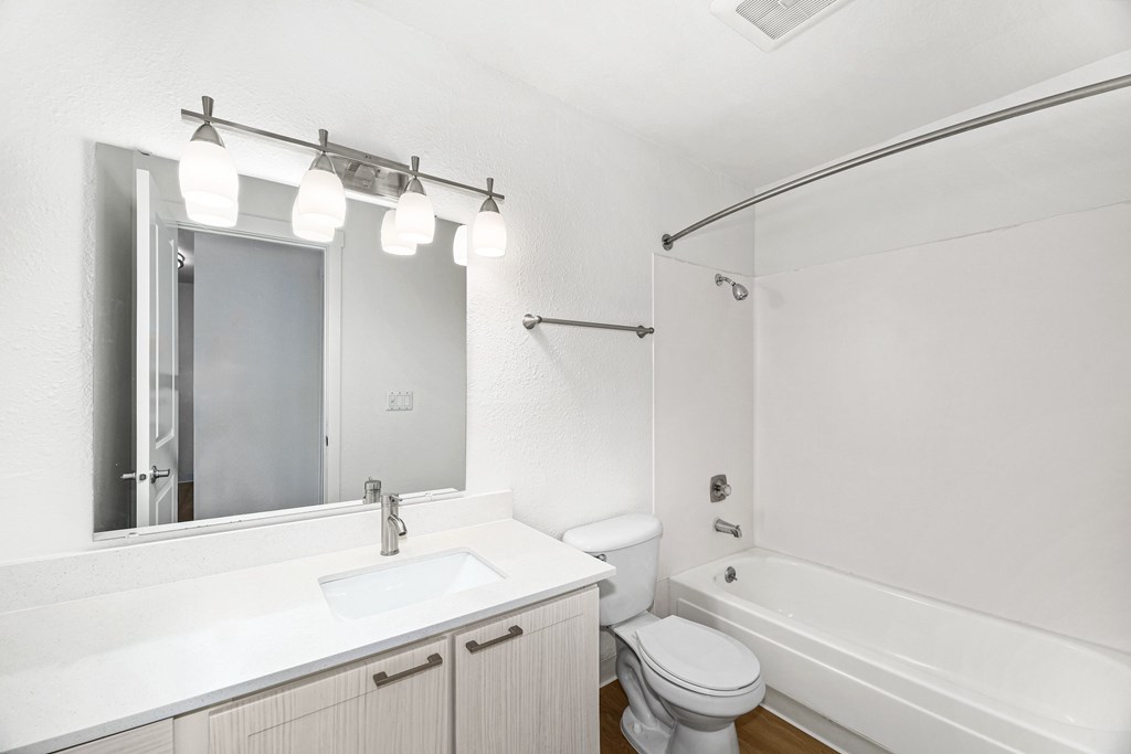 A white bathroom with a toilet, sink, and bathtub.