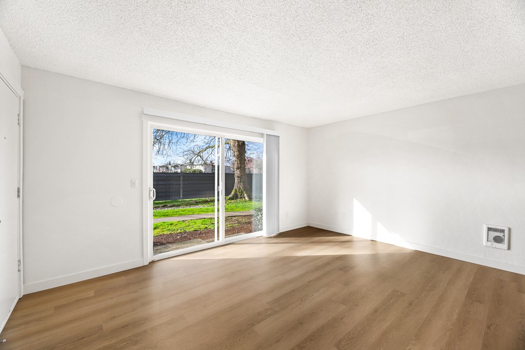 A room with a sliding door leading to a backyard.