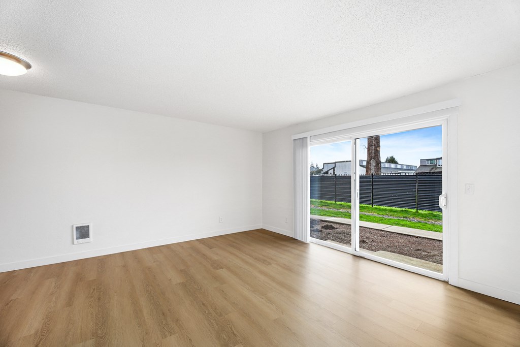 A room with a sliding glass door leading to a backyard.