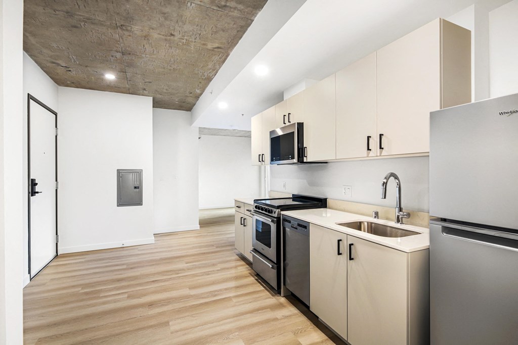A kitchen with wooden floors and stainless steel appliances.