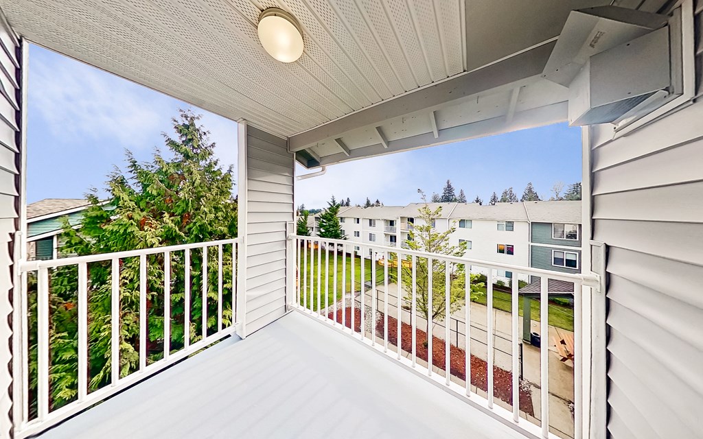 a balcony with white railings and a view of a yard and a house