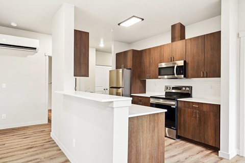 A modern kitchen with wooden cabinets and stainless steel appliances.