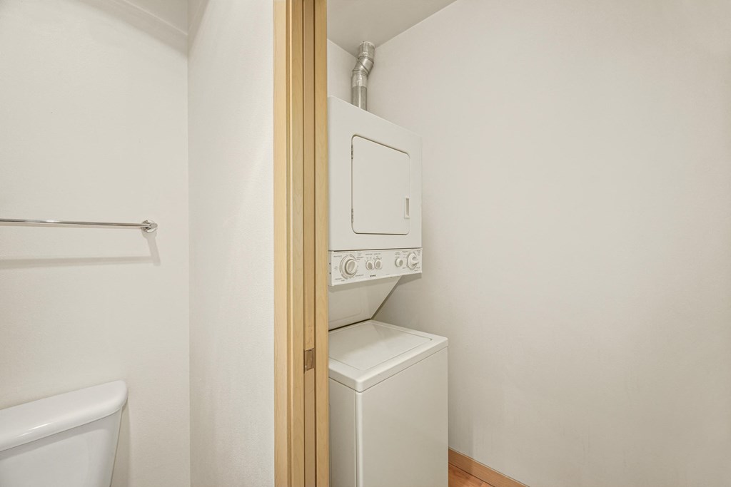 a laundry room with a washer and dryer and a door to the closet