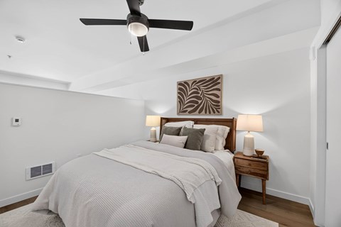 A bedroom with a large bed and a ceiling fan.