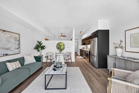 A living room with a green couch, a coffee table, and a large painting on the wall.