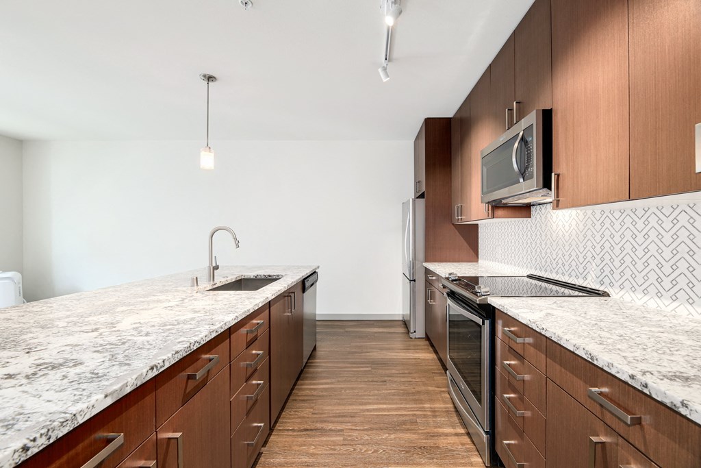 a large kitchen with marble counter tops and wooden cabinets