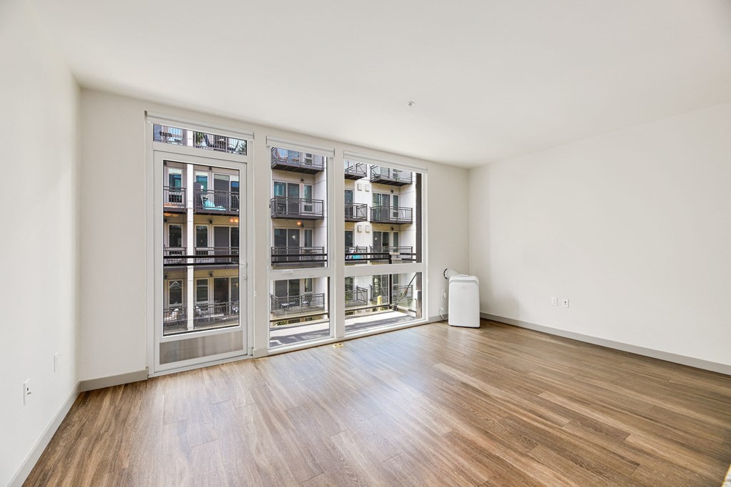 a living room with a large window and a wood floor