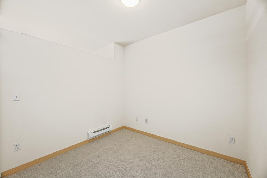 a room with a carpeted floor and a white wall