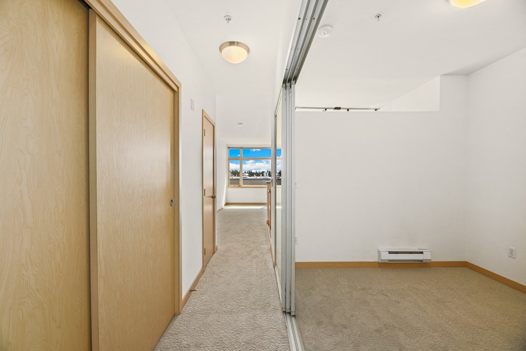 a hallway with a sliding glass door and a carpeted floor