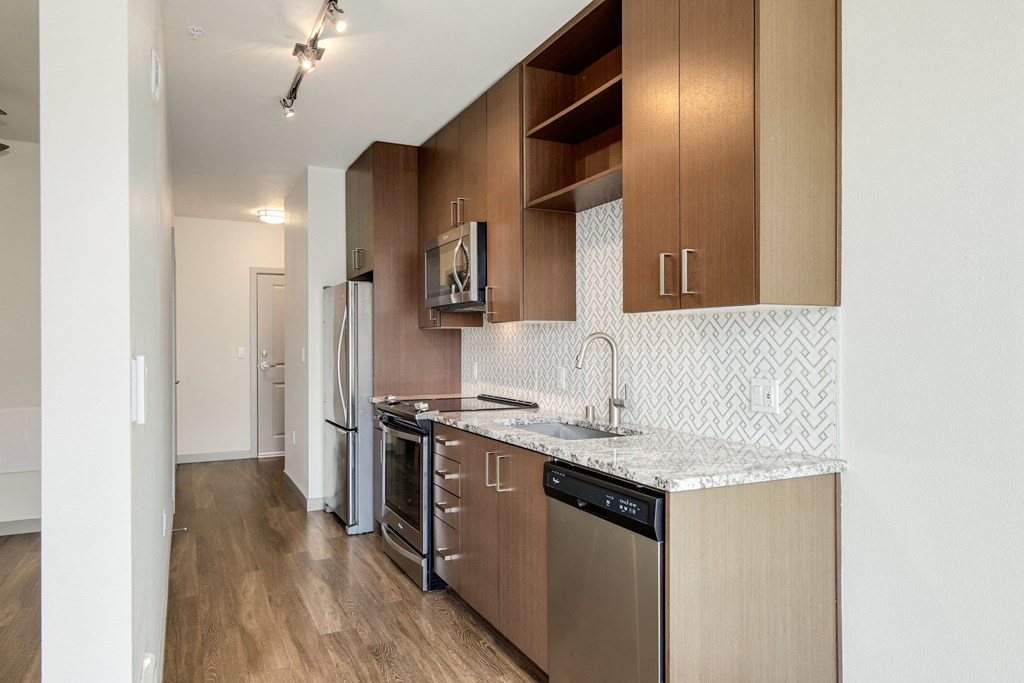 a kitchen with stainless steel appliances and a marble counter top