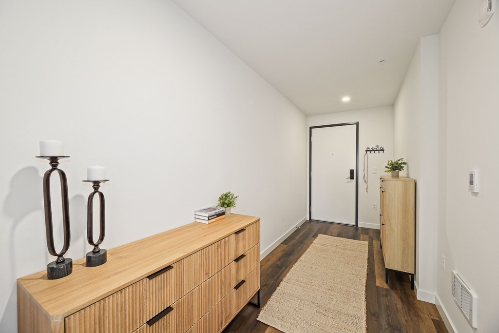 A long wooden table with candles and a book on it.