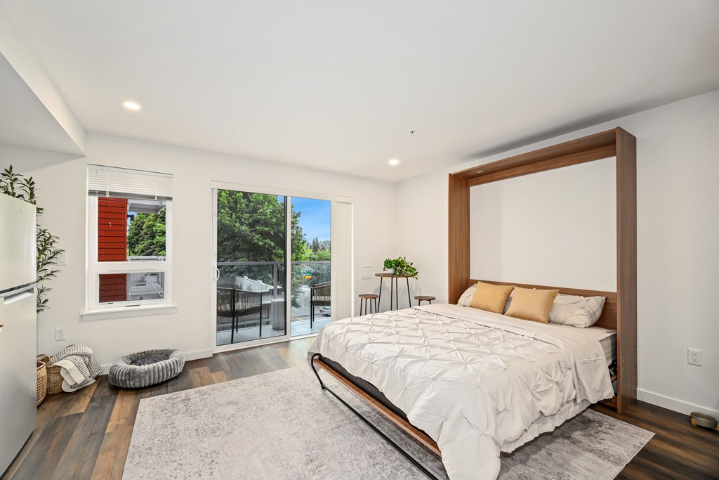 A bedroom with a large bed and a sliding glass door.